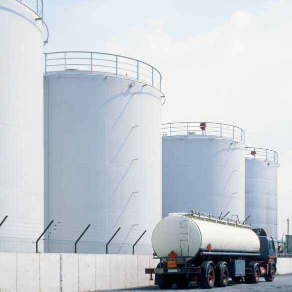 road tanker in front of oil refinery tanks, neutral with copy space